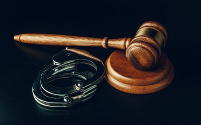 Judge gavel and handcuffs on dark black background